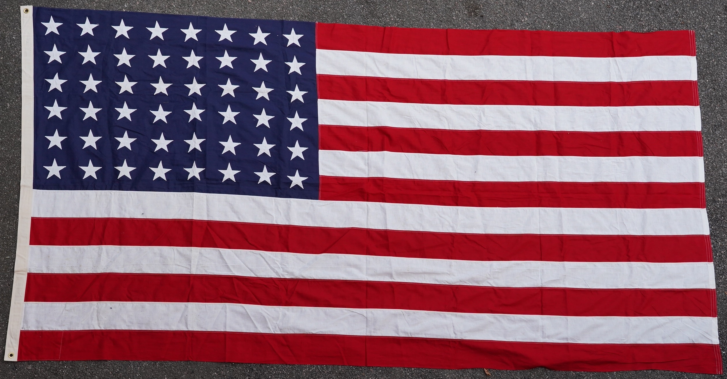 Four flags; two professionally made US Stars and Stripes, both on thick canvas with applied stars and joined stripes, one by the Valley Forge Flag Co., Pennsylvania, stamped “5 x 9.5 ft”, 146 x 288cm and 176 x 300cm, tog